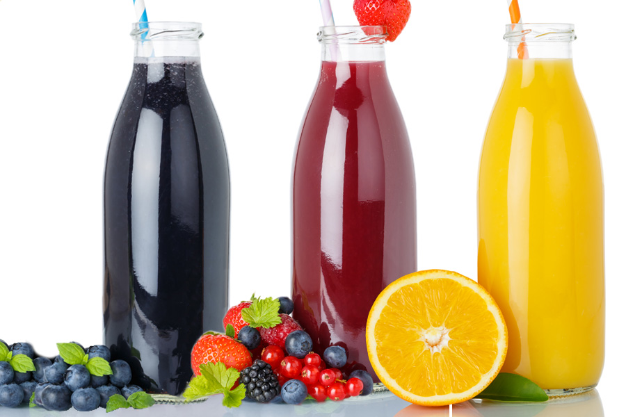 Receta de batido de frutas negras, rojas y doradas Grupo de tres botellas transparentes de boca ancha llenas de batidos negros, rojos y amarillos y una pajita cada una, decoradas con frutas.